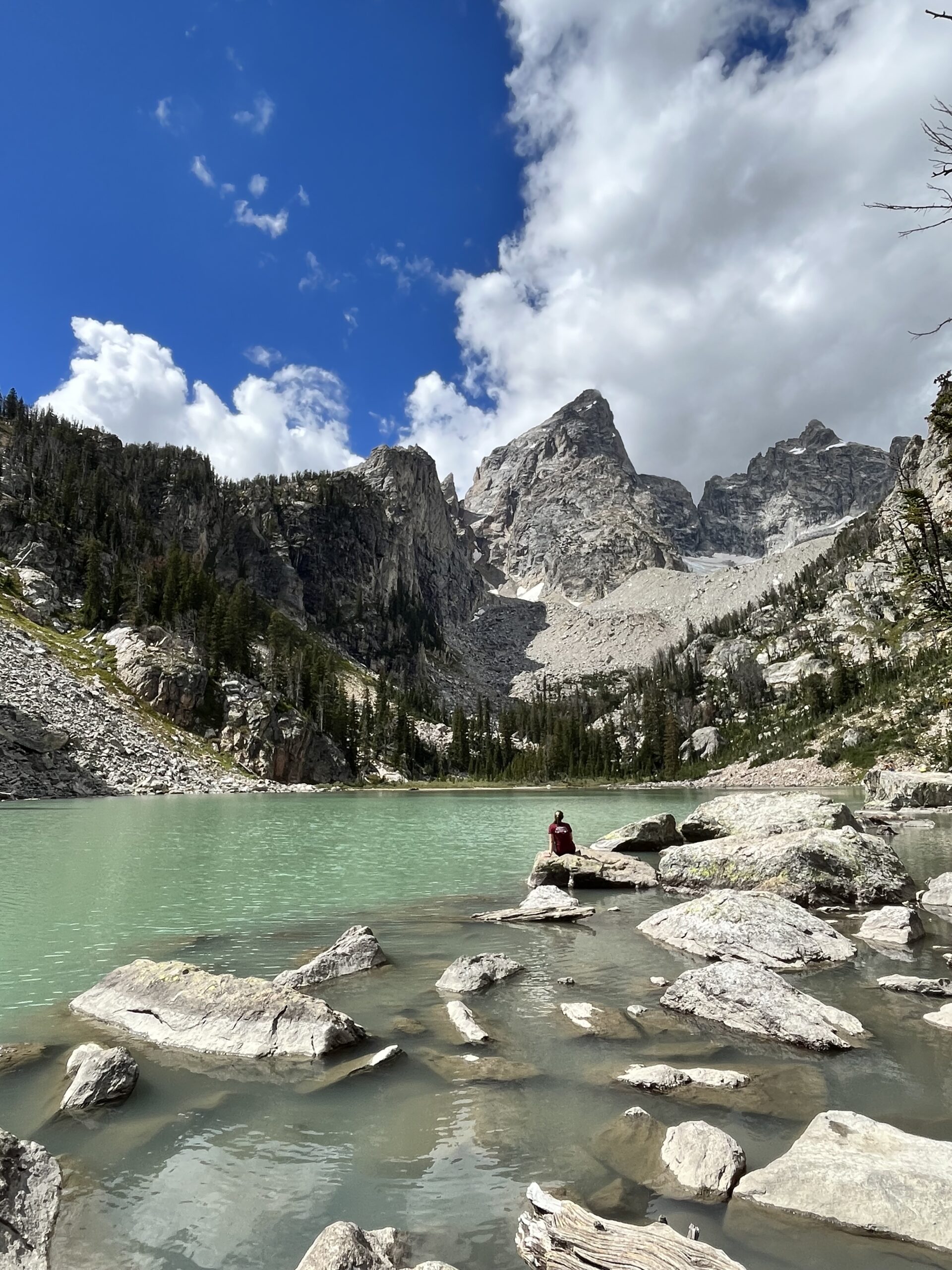 A photo of me sitting next to Delta Lake overlooking the mountain top