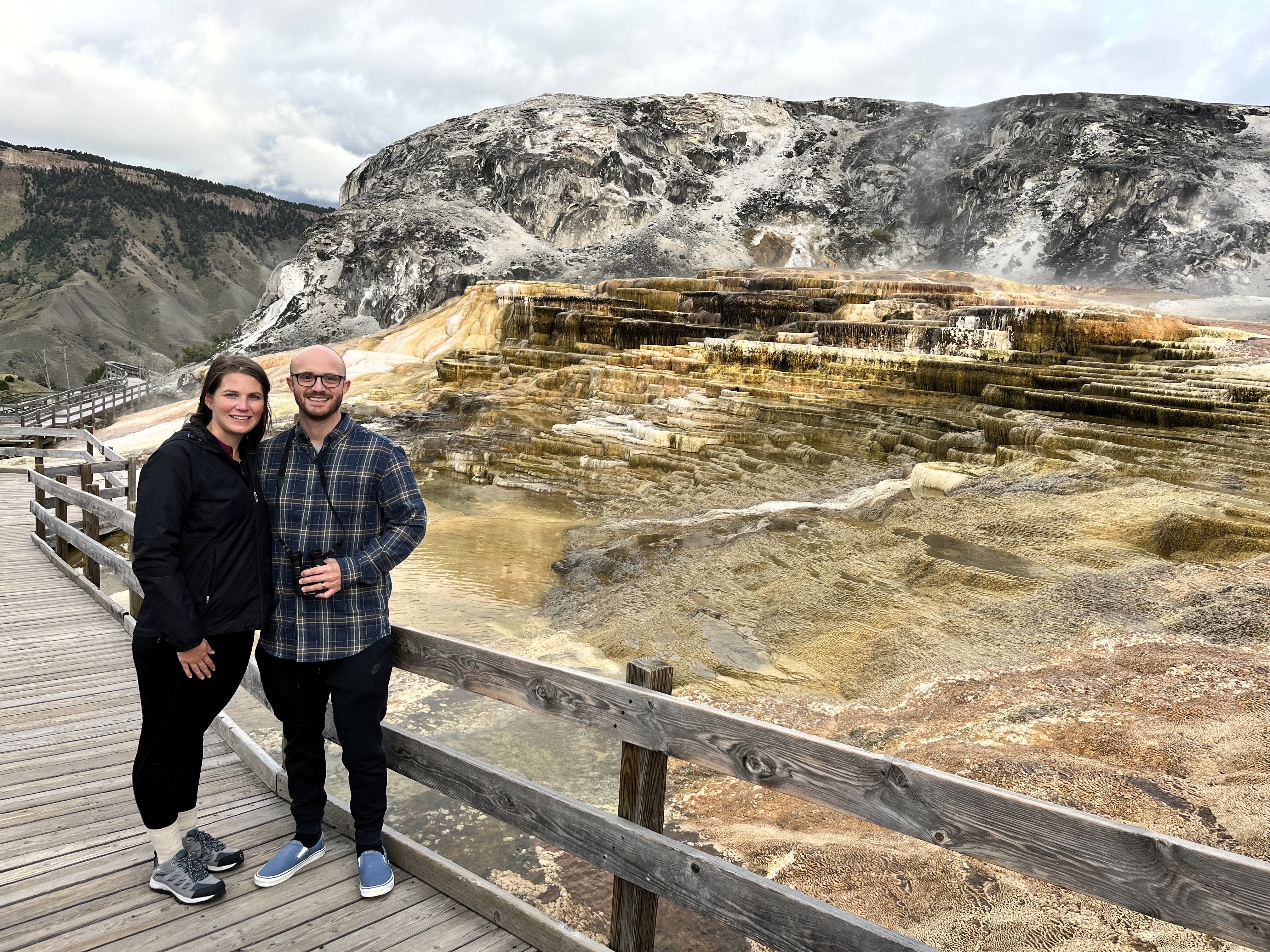 My husband and I standing in front of one of the many hot springs at Mammoth Hot Springs